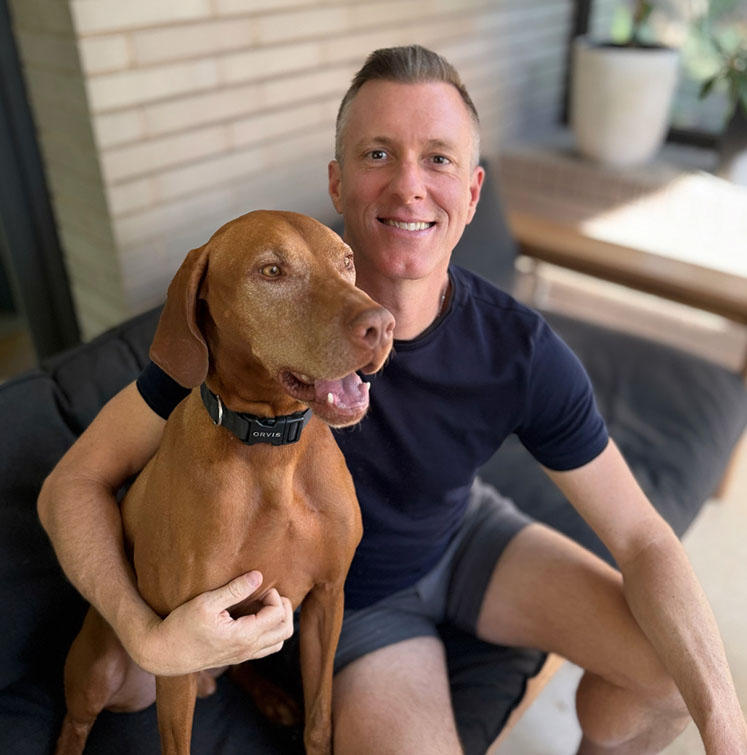 Portrait of Robert Grunnah of Austin House Buyer with his dog sitting on a couch - Sell your house to Austin's Top Cash House Buyer