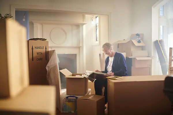 Senior woman packing boxes while downsizing her home in Austin, Texas