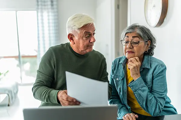 Senior couple reviewing documents while planning to sell their home during retirement in Austin, Texas